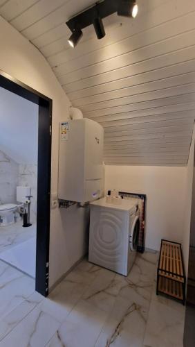 una lavatrice e un'asciugatrice in una stanza con soffitto di WARTEN - Lake Lodge a Bregenz