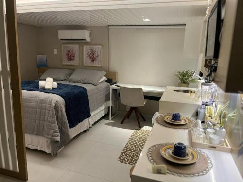 - une chambre avec un lit, un bureau et une table dans l'établissement Flat Tambaú Paradise - 50m da praia Tambaú - João Pessoa, à João Pessoa