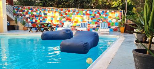 a swimming pool with two inflatablelatable chairs and a swimming pool at African Groove Camps Bay in Cape Town