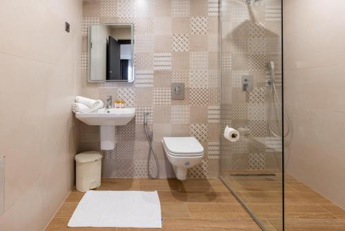 ein Bad mit einer Dusche, einem WC und einem Waschbecken in der Unterkunft coast hotel in Boumerdes
