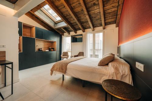 a bedroom with a large bed with two chairs at Casa Pelegrí in Morella