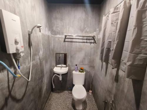 uma casa de banho com um WC e um lavatório em 1 Hati Homestay Sepang em Sepang