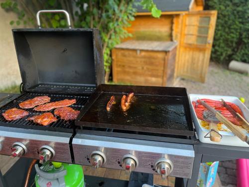 a grill with meat and sausages on it at Gite Villa Avril piscine- jacuzzi- sauna - 15 Pers-proche Europapark in Sélestat