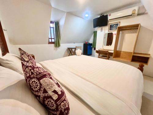 1 dormitorio con cama blanca y almohada en Pijittra Resort en Uttaradit
