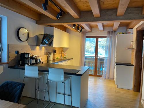 a kitchen with a counter and two bar stools at Golfchalet 3 confini in Tarvisio