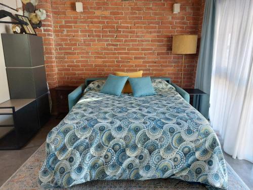 - une chambre avec un lit et un mur en briques dans l'établissement La Buschera, à Bra