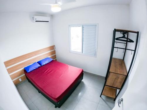 een slaapkamer met een rood bed en een ladder bij Meu Lar Meu Mar 3 in Ubatuba