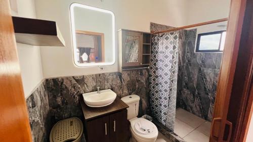 a bathroom with a sink and a toilet and a mirror at Casa #344 - Habitación 3 - Full-Twin Bed - AIR CONDITIONING in Puerto Ayora