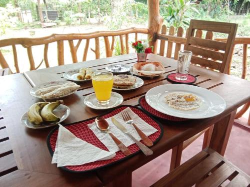 a wooden table with plates of breakfast food on it at Thought Blooming in Udawalawe