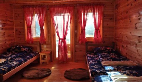 a bedroom with two beds in a log cabin at Eco Village Jasavić II in Plav