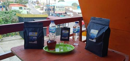a table with two bottles of water and two glasses at Homestay Subarda Kamar Natural in Solok