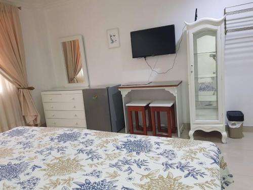 1 dormitorio con 1 cama y TV en la pared en Habitacion independiente en Samborondon, en SamborondÃ³n