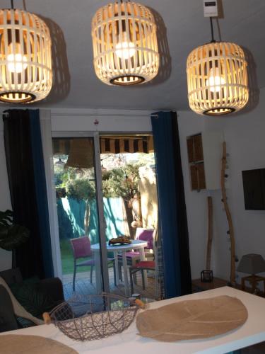 a room with two chandeliers and a table and chairs at Studio le Mistral in Saint-Raphaël