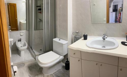 a white bathroom with a toilet and a sink at Appartement Empuriabrava in Empuriabrava