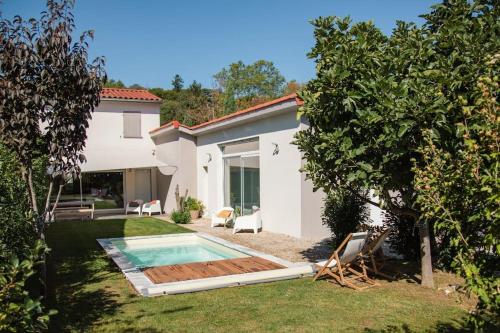 une maison avec une piscine dans la cour dans l'établissement Studio Lyon Collonges au Mont d'Or, à Collonges-au-Mont-dʼOr