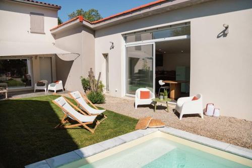 une cour avec des chaises et une piscine dans l'établissement Studio Lyon Collonges au Mont d'Or, à Collonges-au-Mont-dʼOr