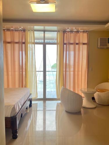a bedroom with a bed and a large window at C View Resort in Sipalay