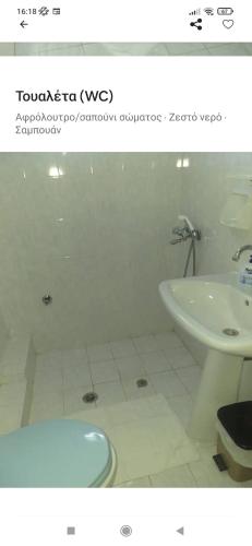 a bathroom with a tub and a toilet and a sink at Άνετο εξοχικό με ιδιωτικό χώρο στάθμευσης in Astrítsa