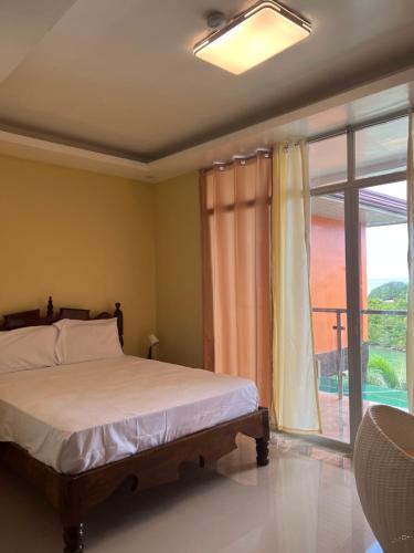 a bedroom with a bed and a large window at C View Resort in Sipalay