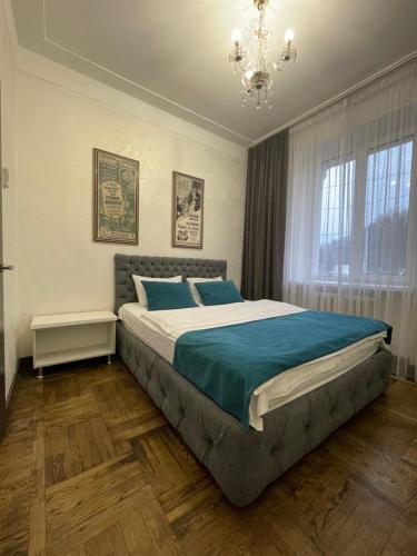 um quarto com uma cama grande e um lustre em Apartment on Soborna 101 em Vinnytsya