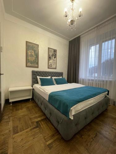 文尼察Apartment on Soborna 101的一间带大床和吊灯的卧室