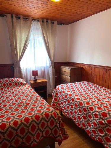 a bedroom with two beds and a window at Ruka Peumayen Caburgua in Caburgua