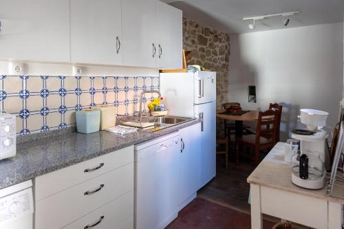 cocina con nevera blanca y fregadero en Casa da Judiaria Velha AP en Viseu