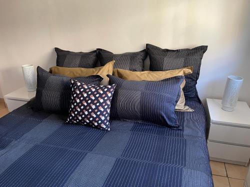 un lit avec un tas d'oreillers dessus dans l'établissement Villa climatisée piscine 3 chambres mer à 800m, à Antibes