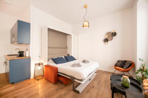 a small bedroom with a bed and a table at Le Laurencin Sens - Le Seventies - Cœur de ville in Sens