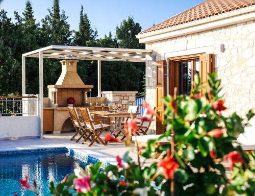 a patio with a table and chairs and a fireplace at Pithari Stone Villa in Fiskardho