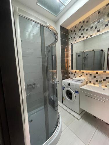 uma casa de banho com um chuveiro e uma máquina de lavar roupa em Apartment on Soborna 101 em Vinnytsya