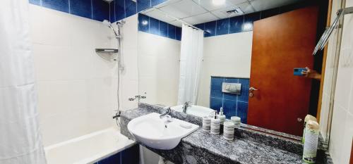 a bathroom with a sink and a tub at A Perfect Escape - Dubai Marina in Dubai