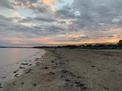a beach with a person walking on the sand at 2 bed Cozy Home Lusk - 15min from Dublin airport! in Lusk