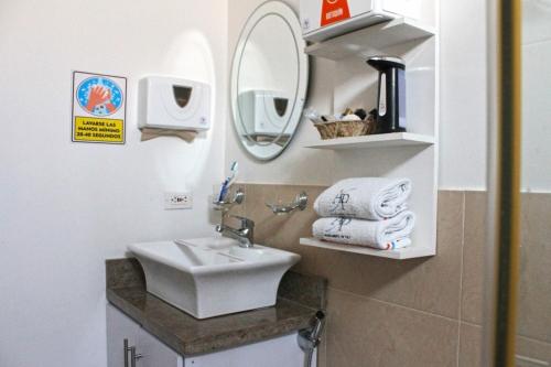 y baño con lavabo, espejo y toallas. en Apartamento de Yuly, en Santa Marta
