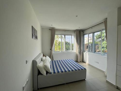 a bedroom with a bed in a room with windows at Apartment in the heart of Accra. in Accra
