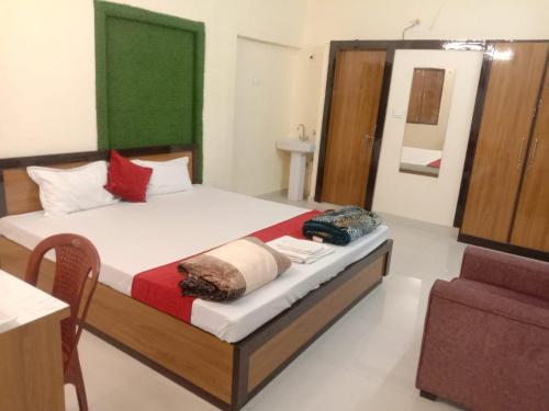 ein Schlafzimmer mit einem Bett, einem Stuhl und einem Spiegel in der Unterkunft A K CONTINENTAL in Ranchi