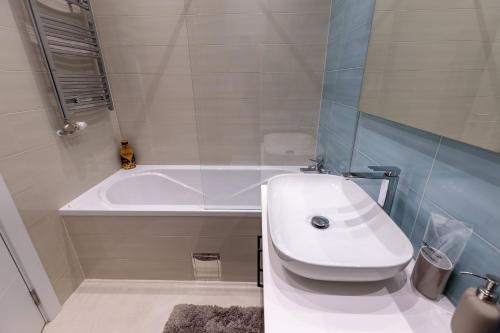 a bathroom with a white tub and a sink at DONNER LUXURY APARTMAN in Subotica
