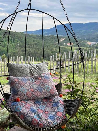 a hanging chair with pillows in a vineyard at Zlatiborski katuni in Zlatibor