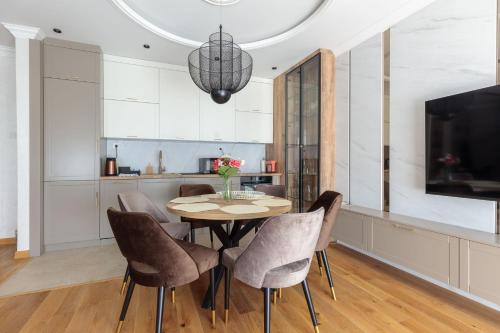 a dining room with a table and chairs at DONNER LUXURY APARTMAN in Subotica