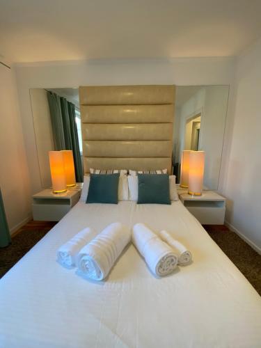 a large white bed with three pillows and two lamps at Charm of Lisbon I in Lisbon