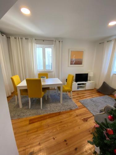 a living room with a white table and yellow chairs at Charm of Lisbon I in Lisbon