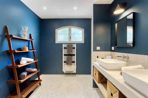 La salle de bains est pourvue de murs bleus et d'un lavabo. dans l'établissement Villa de 277m² climatisée avec piscine chauffée à Fayence, à Fayence