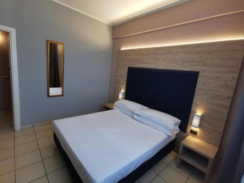 ein Schlafzimmer mit einem großen weißen Bett in einem Zimmer in der Unterkunft Hotel Formula Int. & Puravita SPA in Rosolina