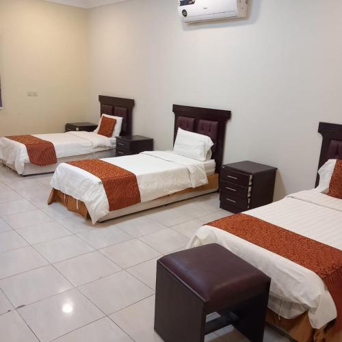 a hotel room with three beds in a room at لؤلؤ الدرب...ليالي ملكية in Qarār