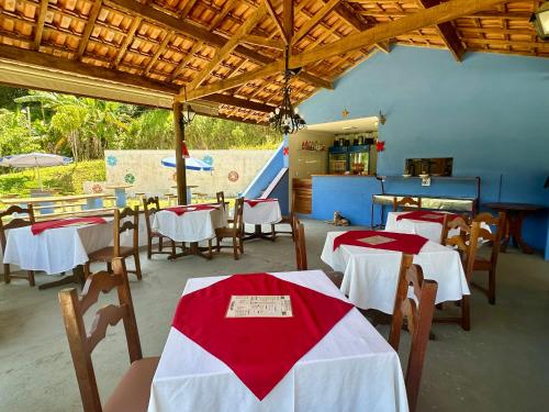 un restaurante con mesas con manteles rojos y blancos en Chalé Recanto Luz Da Montanha en Águas de Lindóia