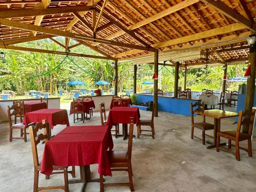 a restaurant with tables and chairs with red table cloth at Chalé Recanto Luz Da Montanha in Águas de Lindóia