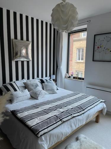 a bedroom with a bed with a striped wall at Chez Céline in Cherbourg en Cotentin