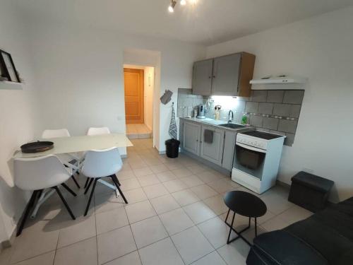 eine kleine Küche mit einem Tisch und Stühlen in einem Zimmer in der Unterkunft T2 aux portes des Cévennes in Lédignan