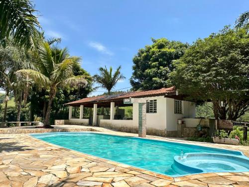 a swimming pool in front of a house at Chalé Recanto Luz Da Montanha in Águas de Lindóia