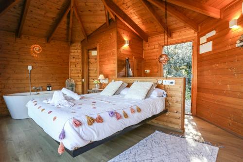 a bedroom with a large bed and a bath tub at Les Suites in Santa María de Palautordera